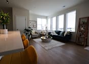 Thumbnail 9 of 30 - A living room with a couch, chairs, and a potted plant.