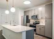 Thumbnail 5 of 35 - A kitchen with a white countertop and grey cabinets.