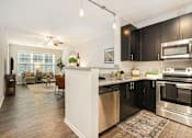 Thumbnail 11 of 30 - A modern kitchen with black cabinets and stainless steel appliances.