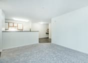 Thumbnail 29 of 37 - A large empty room with a carpeted floor and white walls.
