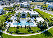 Thumbnail 78 of 78 - A large white building with a pool in the middle of a green lawn.