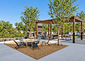 Thumbnail 27 of 29 - A park with a pavilion, chairs, and a table.