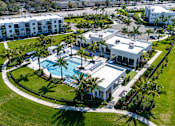Thumbnail 77 of 78 - A large white building with a pool in front of it.