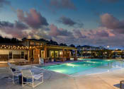 Thumbnail 1 of 46 - Norcross GA Apartments - The Darnell - Pool at Night, with Poolside Seating, Covered Seating Area, and Tables in Background