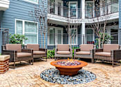 Thumbnail 25 of 26 - a patio with chairs and a fire pit in front of a house