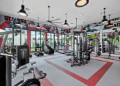 Thumbnail 33 of 78 - a gym with a lot of equipment and windows at Altis Blue Lake, Lake Worth, FL, 33467