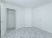 Thumbnail 20 of 37 - A white room with a carpeted floor and two doors.