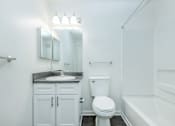 Thumbnail 24 of 37 - A white bathroom with a toilet, sink, and bathtub.