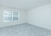 Thumbnail 23 of 37 - A room with a window and carpeted floor.