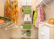 Thumbnail 21 of 34 - A closet with clothes and a dresser.
