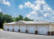 Thumbnail 40 of 46 - a row of white garages with a gray roof
