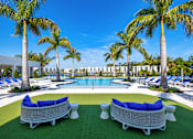 Thumbnail 75 of 78 - A pool surrounded by palm trees and lounge chairs.