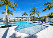 Thumbnail 73 of 78 - A swimming pool surrounded by palm trees and lounge chairs.