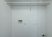 Thumbnail 27 of 37 - A white wall with a small picture frame and two switches.