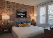 Thumbnail 25 of 40 - a bedroom with a bed and a brick wall
