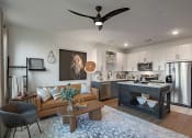 Thumbnail 22 of 40 - a living room with a kitchen and a ceiling fan