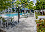 Thumbnail 40 of 49 - A pool area with chairs and tables.