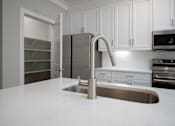 Thumbnail 61 of 67 - a kitchen with white cabinets and a white counter top