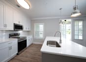 Thumbnail 55 of 67 - a kitchen with white cabinets and a white counter top