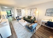 Thumbnail 9 of 38 - A living room with a green couch and a white coffee table.