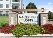 Thumbnail 56 of 60 - a sign for main street lofts in front of flowers