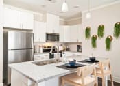 Thumbnail 21 of 60 - a kitchen with a granite counter top and a stainless steel refrigerator