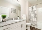 Thumbnail 29 of 60 - a bathroom with a shower and a sink and a toilet