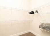 Thumbnail 32 of 60 - a white closet with shelves and a bed in it