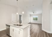 Thumbnail 37 of 60 - an empty kitchen and living room with white cabinets and a sink