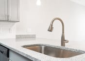 Thumbnail 38 of 60 - a kitchen counter with a sink and a wall with pictures of people