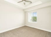 Thumbnail 40 of 60 - an empty living room with a ceiling fan and a window