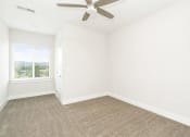 Thumbnail 41 of 60 - an empty living room with a ceiling fan and a window