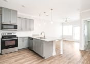 Thumbnail 50 of 60 - an empty kitchen with white cabinets and stainless steel appliances