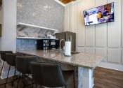 Thumbnail 4 of 60 - a kitchen with a bar and a television on the wall