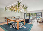 Thumbnail 7 of 36 - A modern dining room with a wooden table and chairs.