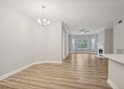 Thumbnail 27 of 36 - A room with wooden flooring and a chandelier hanging from the ceiling.