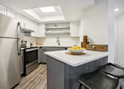 Thumbnail 2 of 28 - Atlanta, GA, Apartments Near Piedmont Park - Virginia Highlands -  Kitchen with Hardwood Floor, Granite Countertops, Stainless Steel Appliances, and Island Counter with Bar Seating.