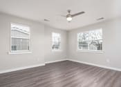 Thumbnail 30 of 48 - A room with a ceiling fan and two windows.