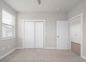 Thumbnail 31 of 48 - A room with a ceiling fan and three white doors.