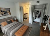 Thumbnail 17 of 36 - A bedroom with a bed, a bench, and a painting on the wall.