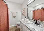 Thumbnail 25 of 59 - A bathroom with a toilet, sink, and shower curtain.