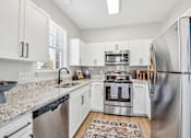 Thumbnail 3 of 59 - A kitchen with white cabinets and stainless steel appliances.