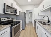 Thumbnail 5 of 59 - A kitchen with white cabinets and granite countertops.