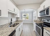 Thumbnail 6 of 59 - A kitchen with granite countertops and white cabinets.