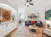 Thumbnail 9 of 59 - A living room with a couch, a coffee table, and a painting on the wall.
