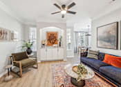 Thumbnail 10 of 59 - A living room with a blue couch and a wooden chair.