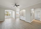 Thumbnail 50 of 59 - A spacious room with a ceiling fan and light wood flooring.