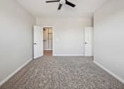 Thumbnail 58 of 59 - A room with a ceiling fan and carpeted floor.