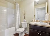 Thumbnail 18 of 42 - A white toilet sits next to a white sink in a bathroom.