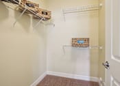 Thumbnail 15 of 42 - A hallway with two shelves and baskets on them.